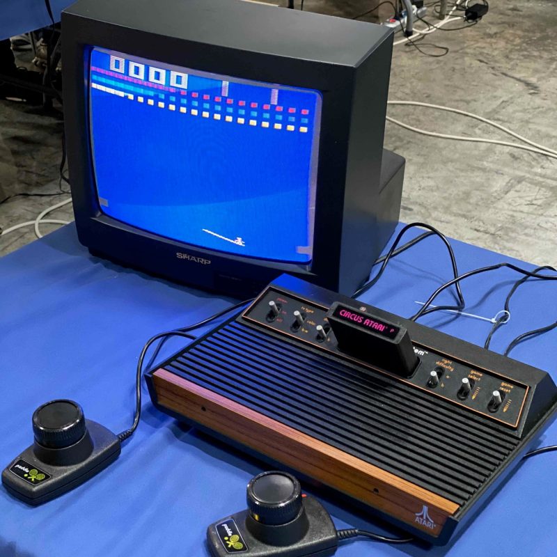 An Atari 2600 running Circus Atari on a Sharp CRT with two paddle controllers, set up to play at the Retro Barcelona convention.
